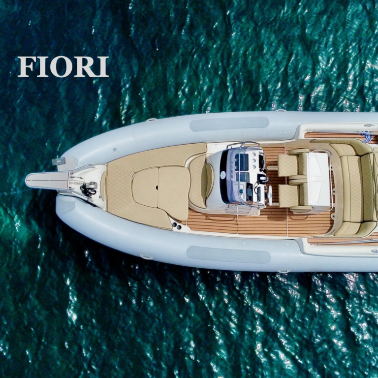 High-angle view of an empty white and tan boat hull on water, labeled "FLORI".